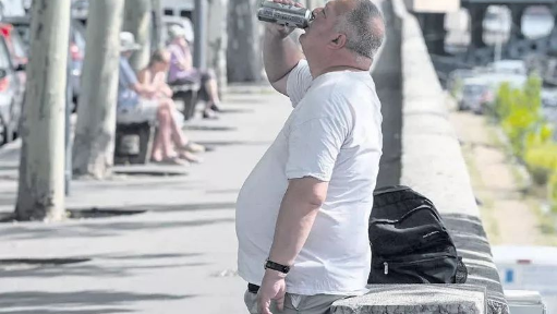 巴黎塞納河邊喝啤酒消暑的男子